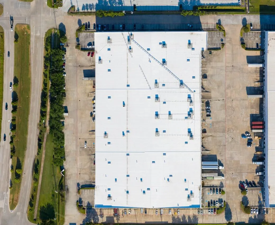 Overhead view of a white commercial roof with rooftop units