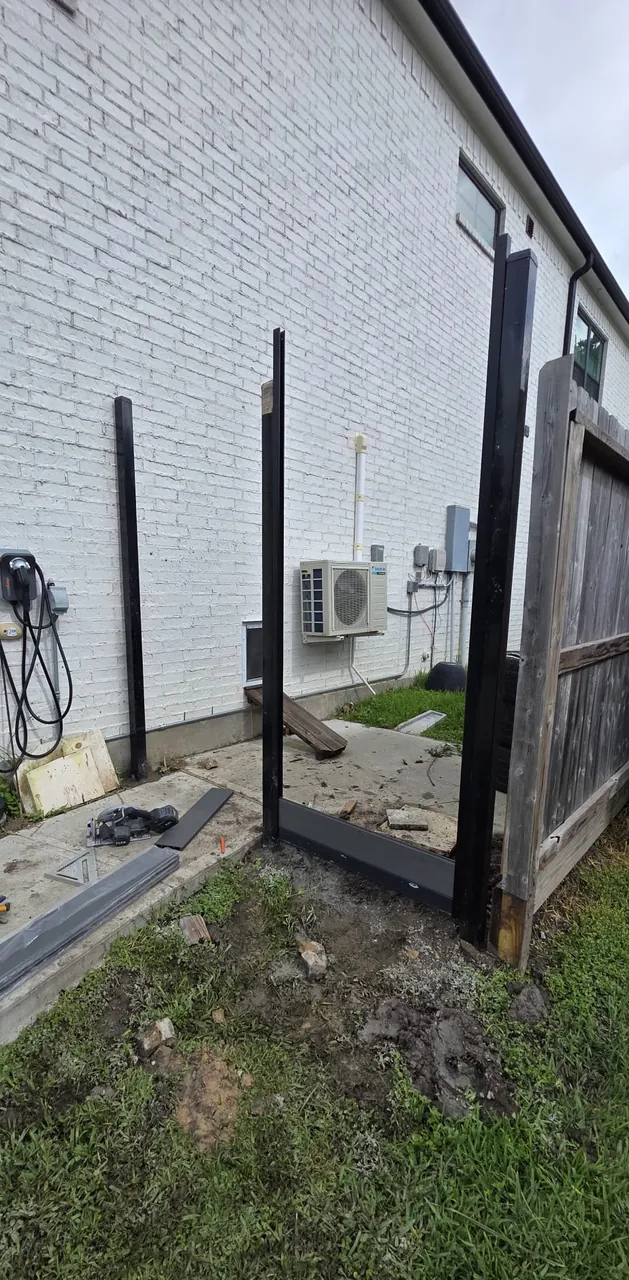 Structural fence posts positioned during the fence installation process.