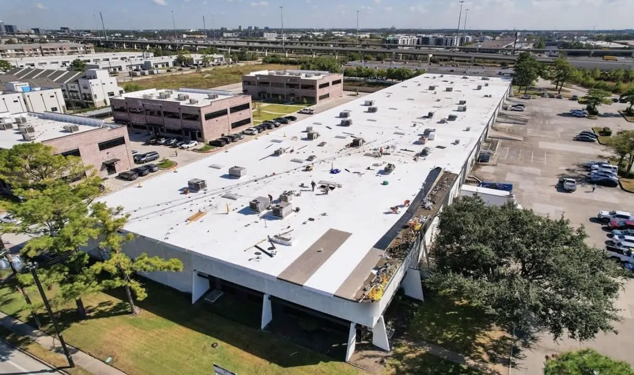 Commercial low-slope roof with white membrane during roofing work