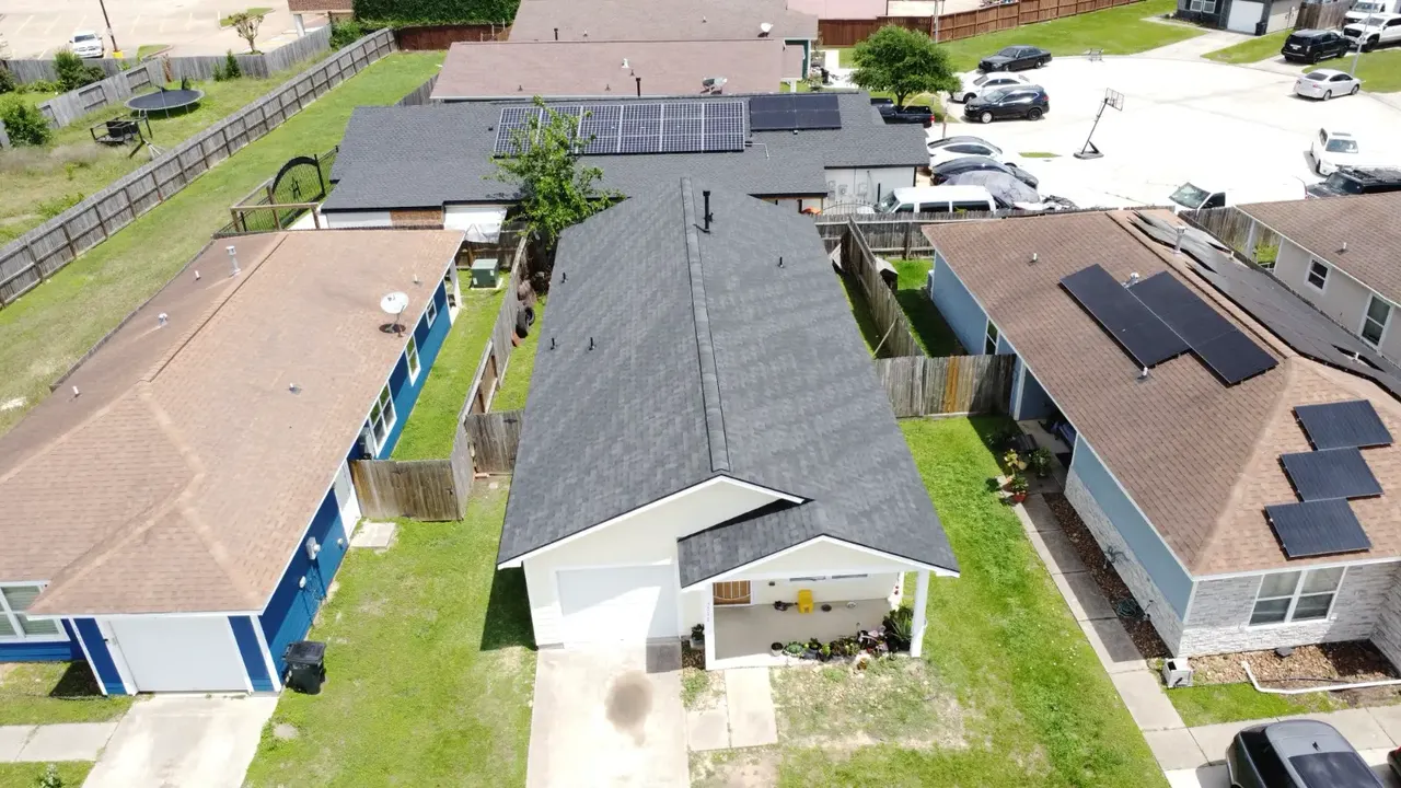 Aerial view of a dark shingle roof with a straight ridge line on a single-story home