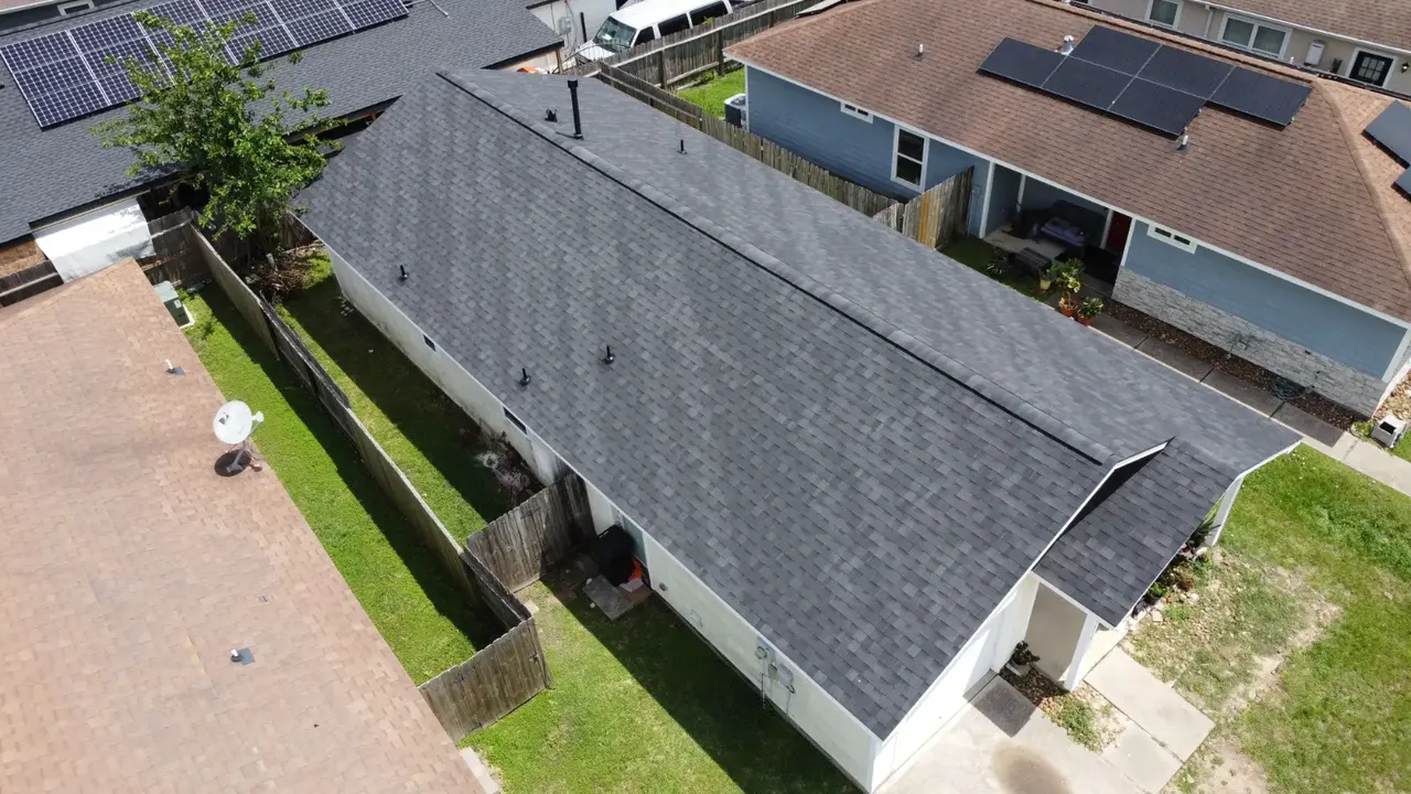 Close aerial detail of new dark shingles, ridge cap and roof vents