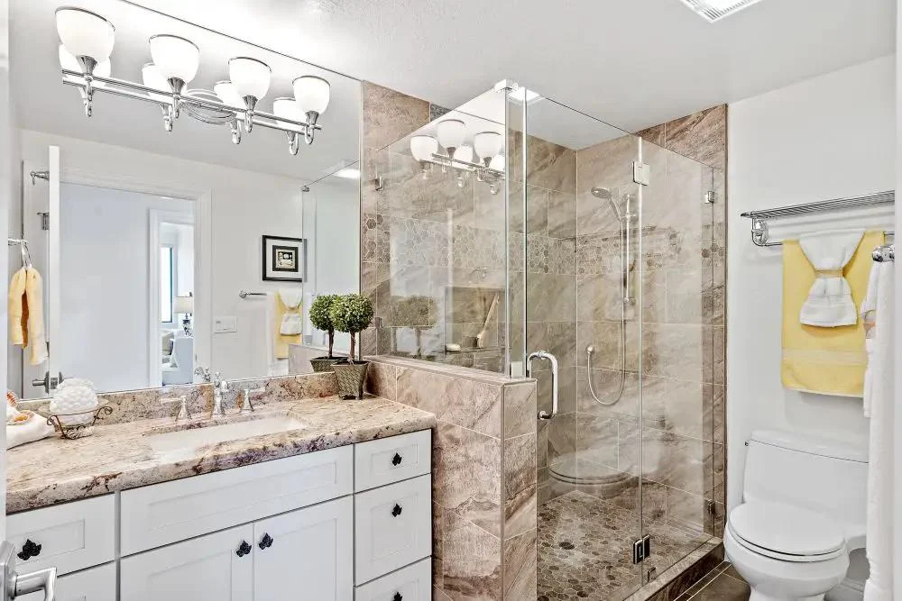 Bathroom example with vanity, tiled shower and glass enclosure.