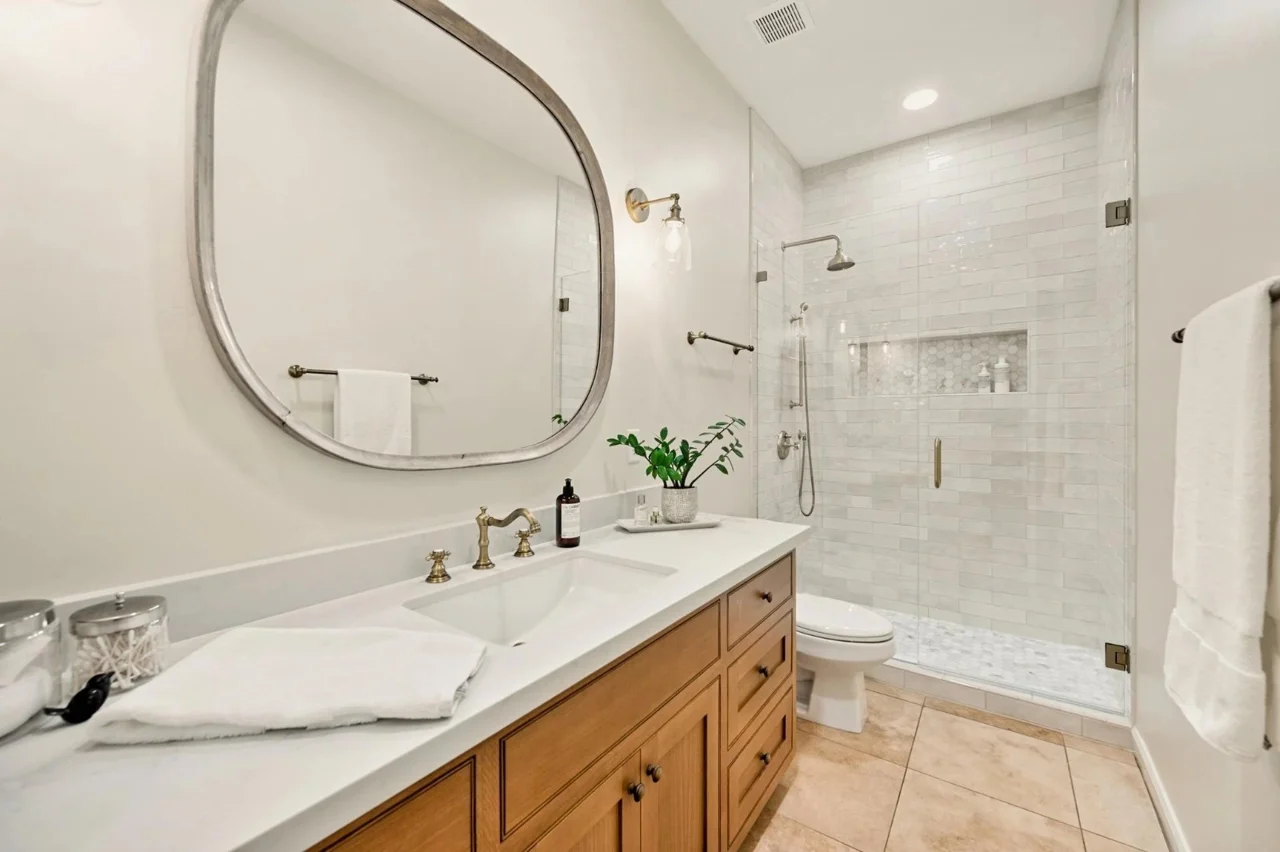 Bathroom example with vanity, mirror and glass shower enclosure.